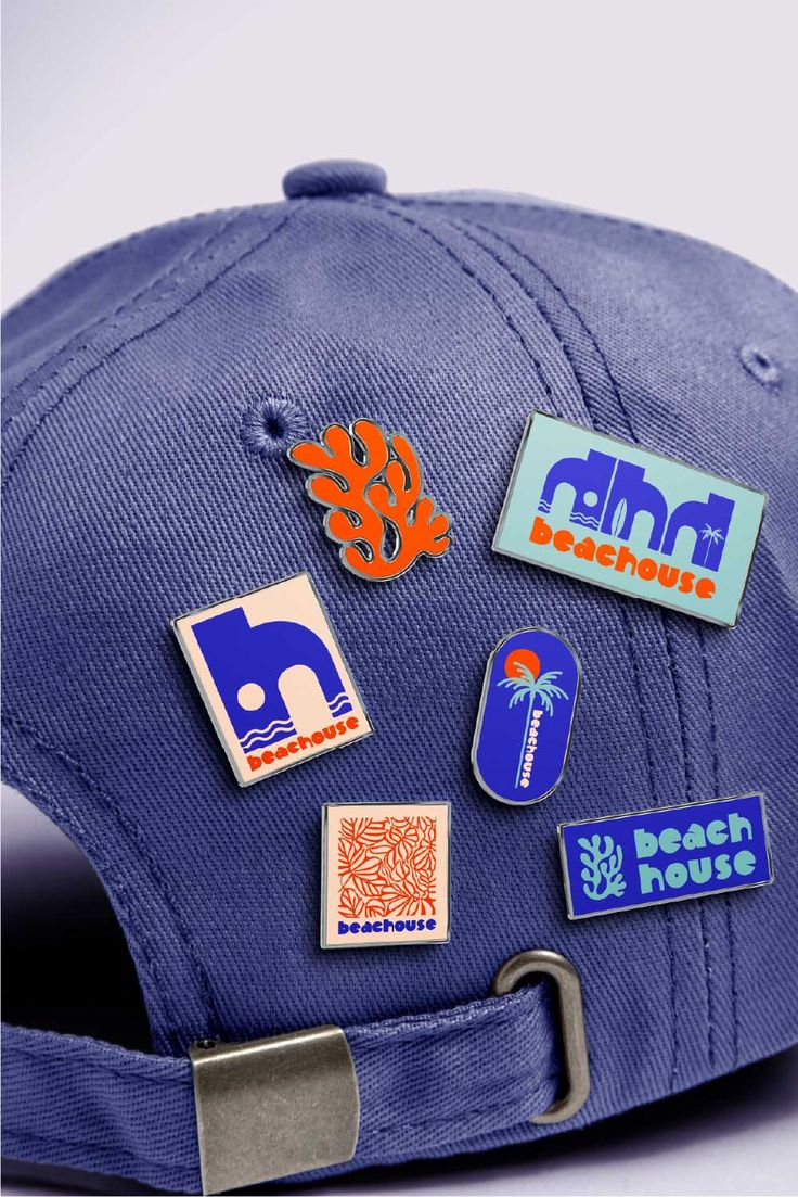 a blue hat with various stickers on the front and back of it's brim