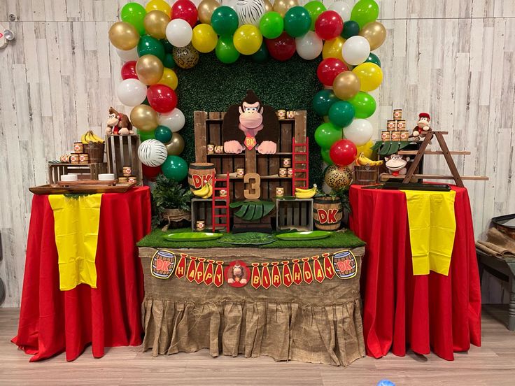 a table topped with lots of balloons and decorations