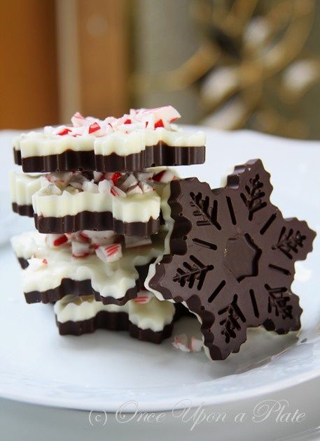 three pieces of chocolate with white and red sprinkles on them sitting on a plate