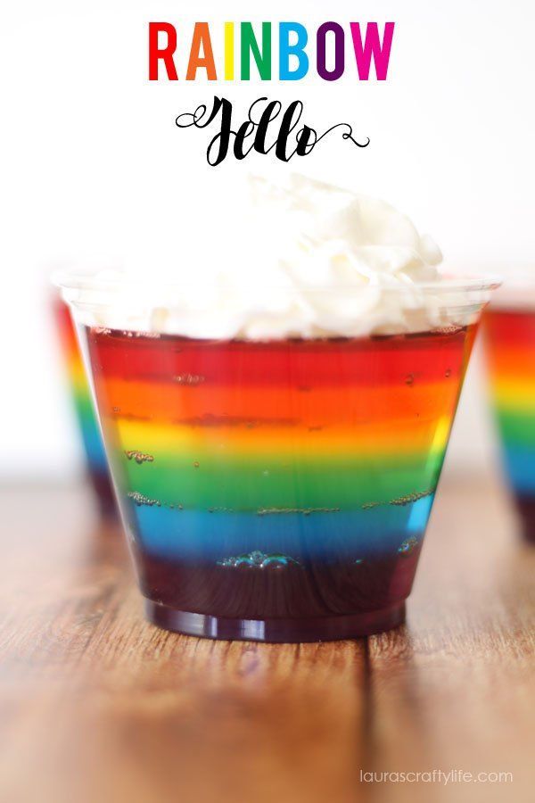 rainbow jello with whipped cream on top and the words, rainbow jello above it