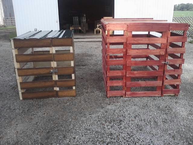 two wooden crates sitting next to each other in front of a white building on gravel