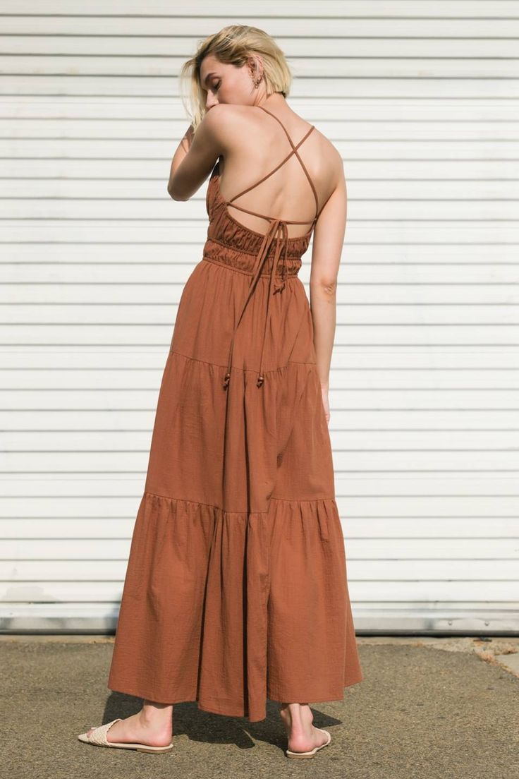 A solid woven maxi dress featuring shirred cami top with center cut out, tiered skirt and bare back with strap tie/tassel Details: Self : 100% Cotton Size & Fit - Model is 5`9" And Wearing Size Small- Measurements Taken From Size Small- Approx. Length: 48" Chic Backless Maxi Dress With Tie Straps, Summer Ruched Tiered Maxi Dress, Summer Tiered Ruched Maxi Dress, Summer Tiered Skirt Maxi Dress With Tie Back, Bohemian Tiered Maxi Dress With Tie Straps, Tiered Maxi Dress With Tie Back For Brunch, Bohemian Backless Maxi Dress With Adjustable Straps, Solid Color Bohemian Dress With Smocked Back, Solid Color Tiered Beach Dresses