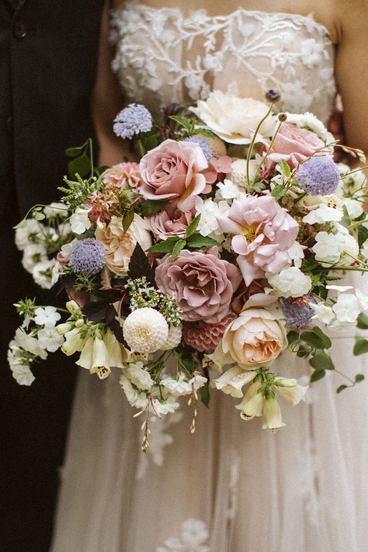 a bride and groom holding a bouquet of flowers