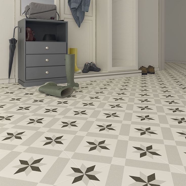 a white and black tiled floor in a room with clothes on the closet door, coat rack and shoes