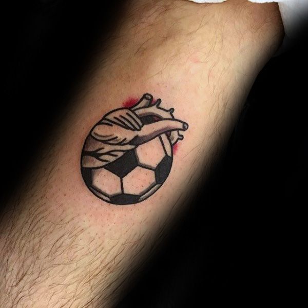 a man's arm with a tattoo on it that has a soccer ball in the shape of a heart