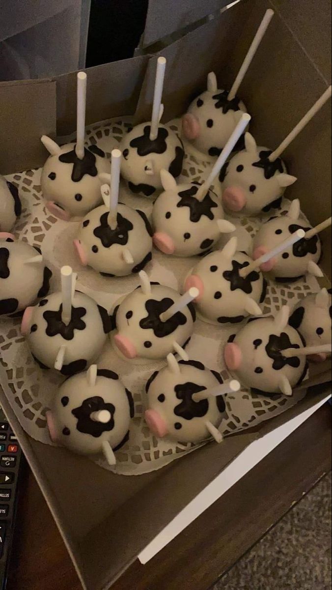 a box filled with cupcakes covered in frosting and decorated like cow's