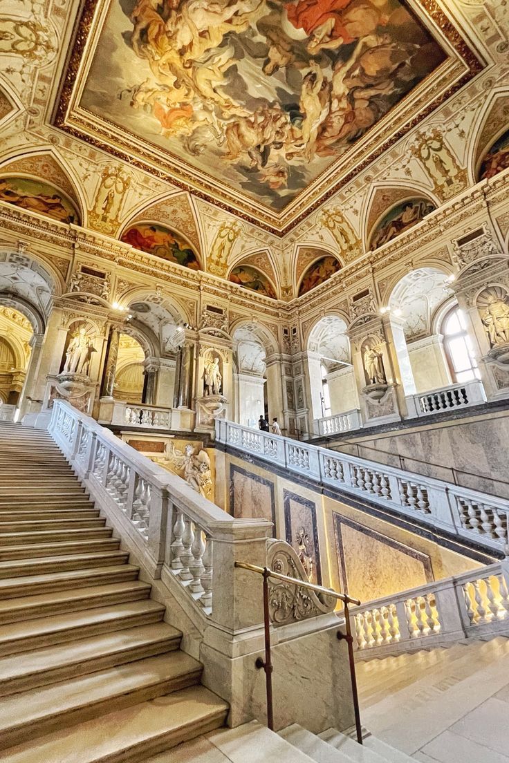 an ornate staircase with paintings on the ceiling