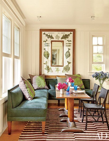 a living room with green couches and striped rugs on the hardwood flooring