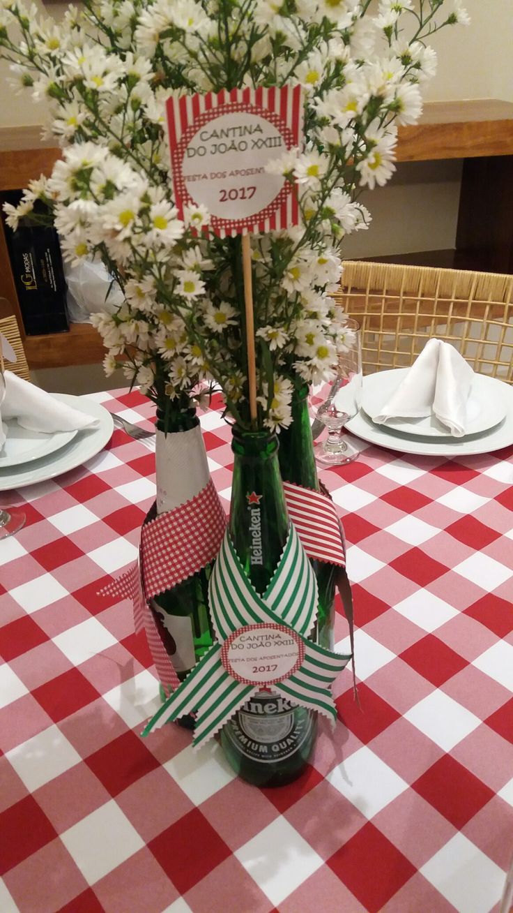 a table with red and white checkered table cloth, vases filled with flowers