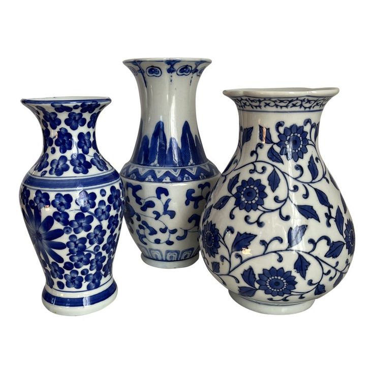 three blue and white vases sitting next to each other