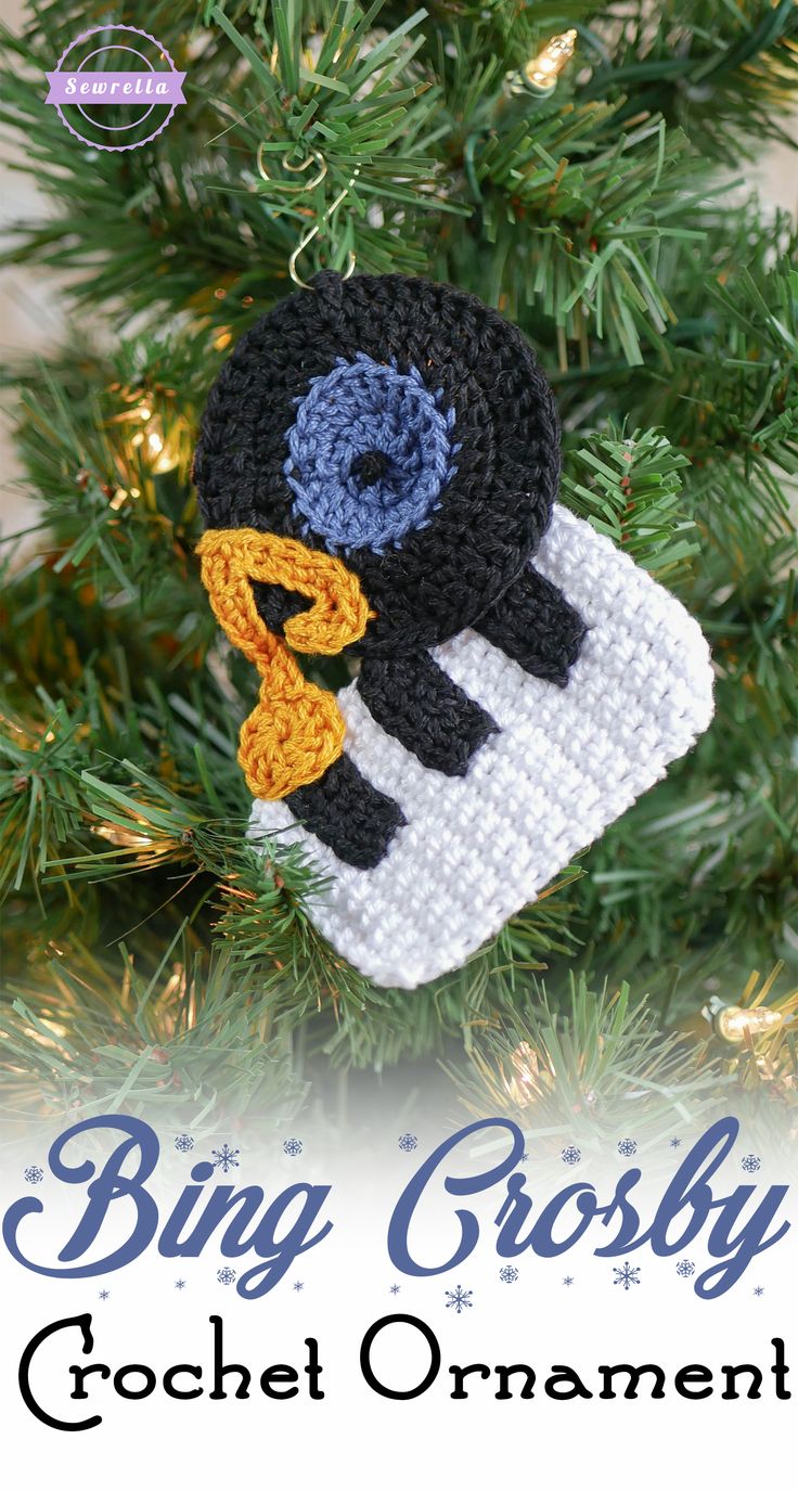 a crocheted penguin ornament hanging from a christmas tree