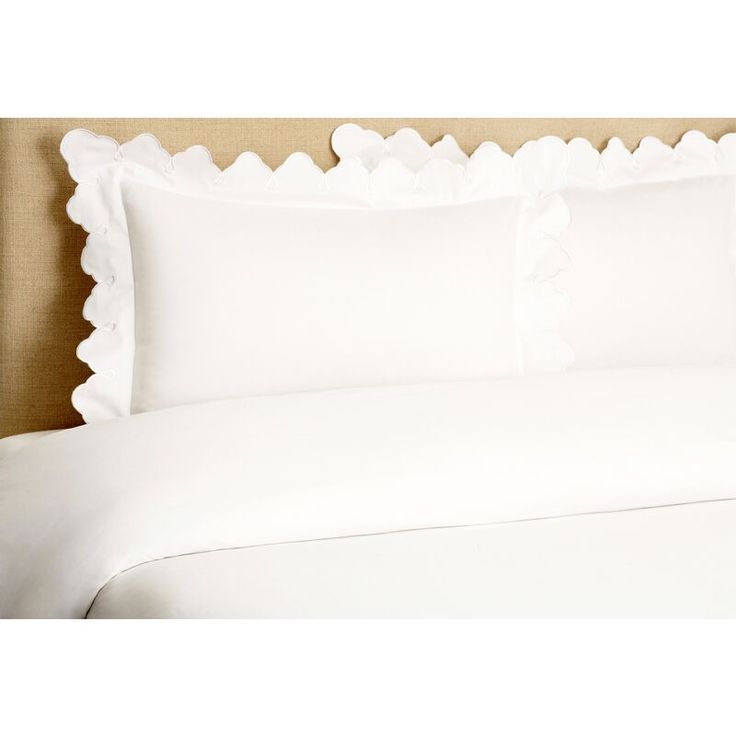 a bed with white sheets and ruffled edges