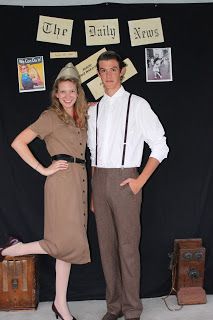 a man and woman standing next to each other in front of a black wall with signs on it