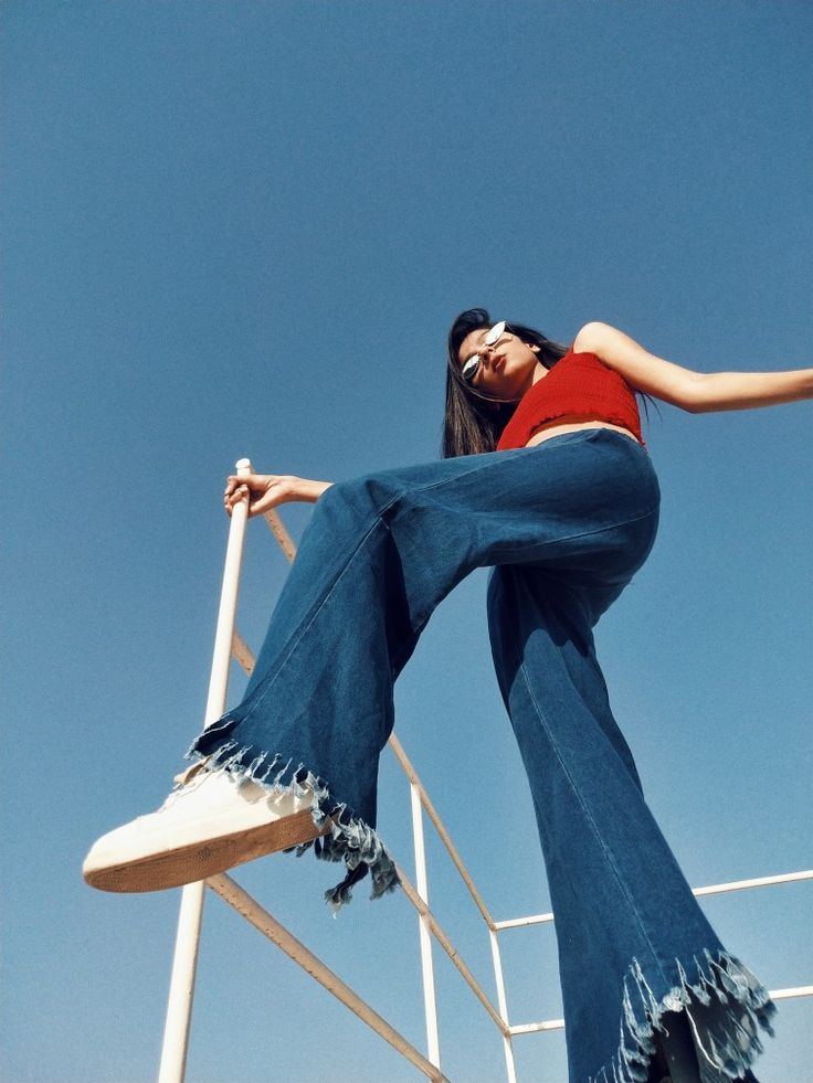 a woman leaning up against a metal railing