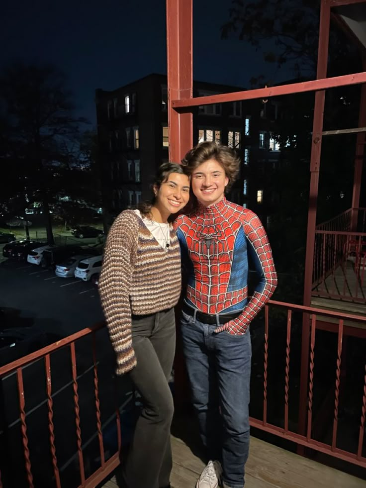 two people standing next to each other on a balcony