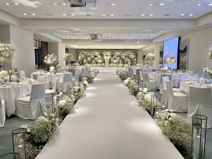 an indoor wedding setup with white flowers and greenery