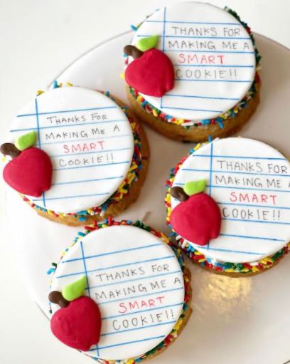 three decorated cookies with writing on them sitting on a white plate next to each other