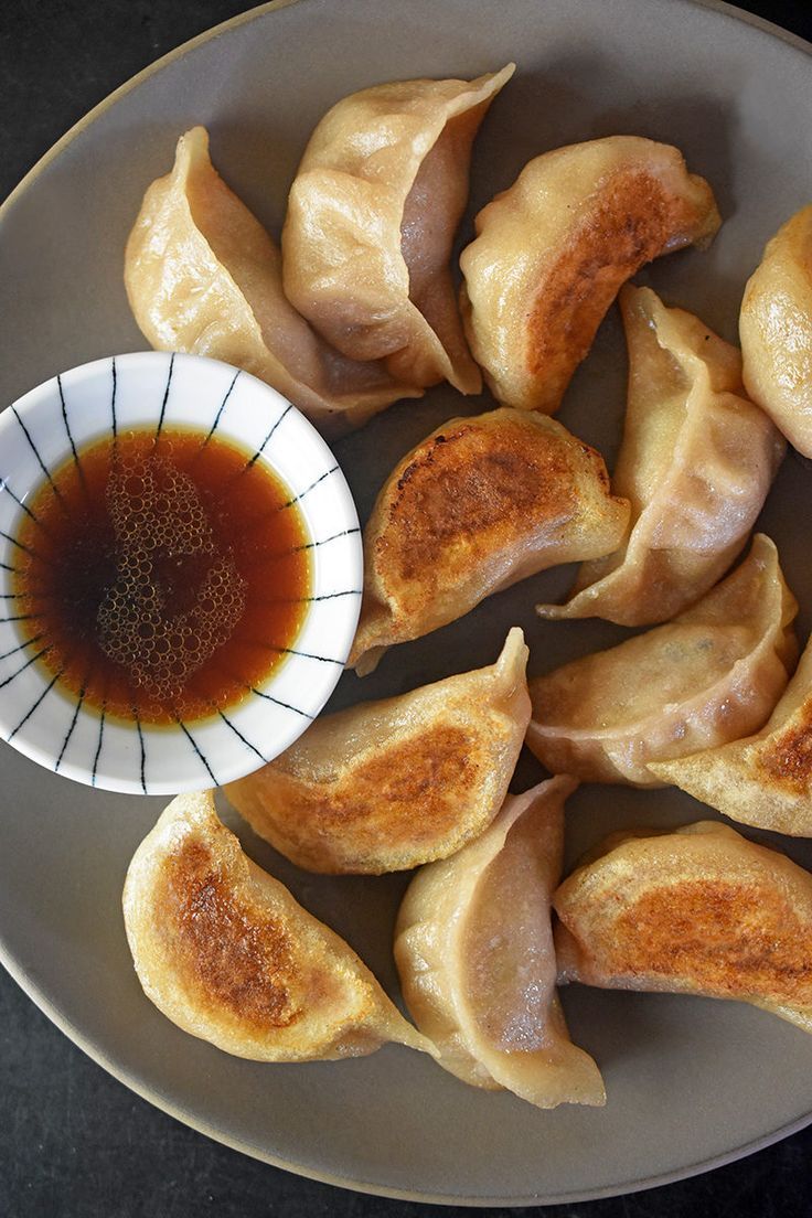 some dumplings on a plate with dipping sauce