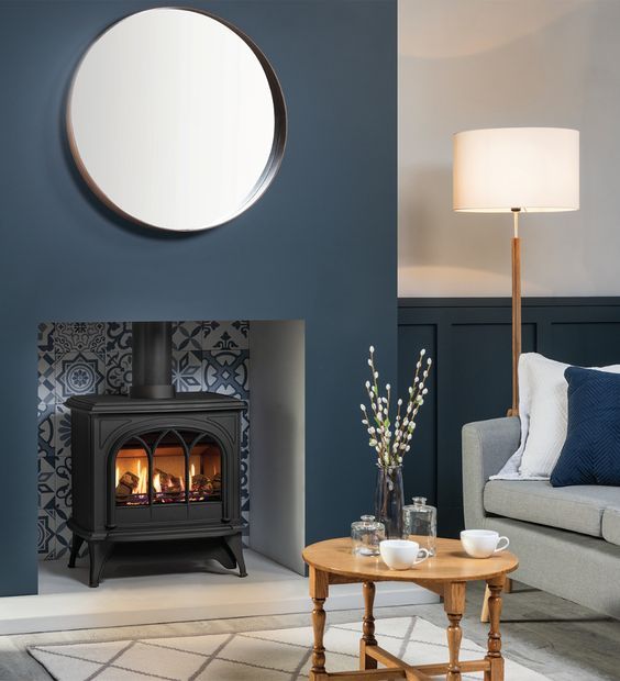 a living room filled with furniture and a fire place next to a wall mounted mirror