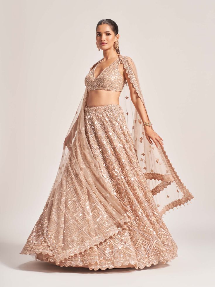 Editors Note Elevate your style with this resplendent gold tulle lehenga, meticulously hand-embroidered with ornamental lustre sequences and japanese bugle beads. Accompanied by a scalloped dupatta adorned with crystal drops and a matching blouse, this ensemble exudes opulent charm and sophistication. Scalloped Dupatta, Tulle Lehenga, Editors Note, Latest Bollywood Movies, Gold Tulle, Wedding Lehenga Designs, Embroidered Lehenga, Wedding Lehenga, Lehenga Designs