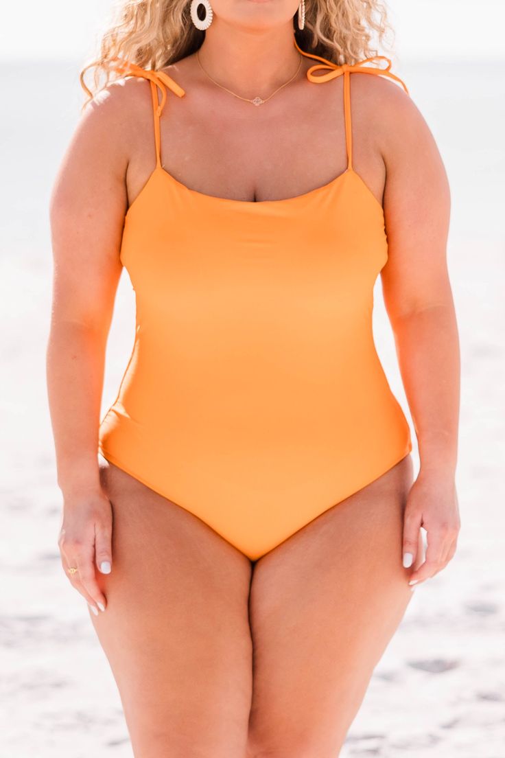 This suit is sure to be your go to style for your new fresh seaside look. The design allows for the perfect amount of coverage while sporting cute tie straps with a vibrant orange color! Whether you decide to lounge in the cabana or relax poolside, you are ready for all things summer with this beauty! 80% Nylon, 20% Spandex Orange Tankini For Summer Beach Party, Orange Swimwear With Adjustable Straps, Solid Color Swimwear With Spaghetti Straps For Sunbathing, Solid Swimwear With Spaghetti Straps For Sunbathing, Orange Summer Swimwear For Sunbathing, Orange Summer Tankini For Poolside, Orange Swimwear With Adjustable Straps For Pool, Fitted Orange Swimwear With Adjustable Straps, Orange Summer Tankini For Vacation