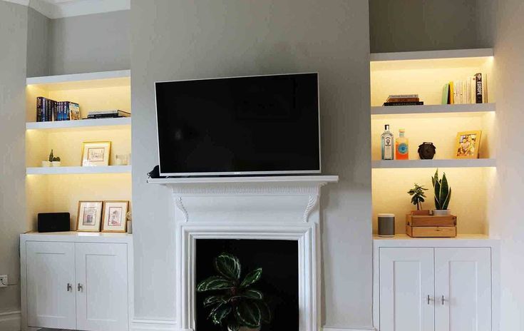 a flat screen tv mounted to the side of a wall next to a fire place