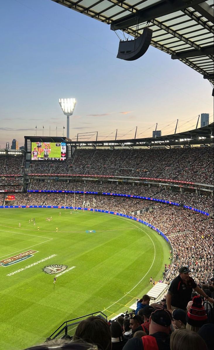 a large stadium filled with lots of people watching a soccer game on the big screen