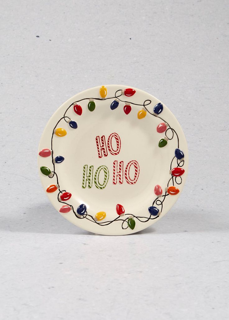 a white plate with the words oh oh on it and multicolored christmas lights