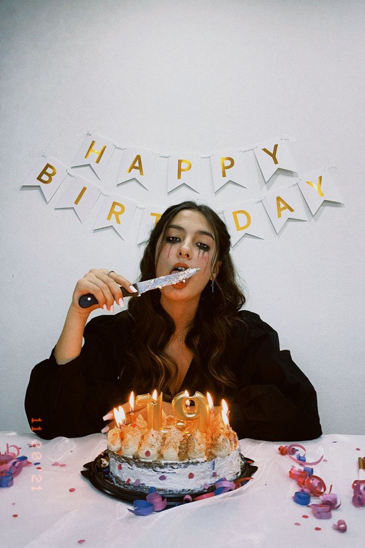 a woman is blowing out candles on her birthday cake