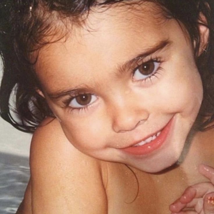 a close up of a child in the bathtub with water on her face and hair