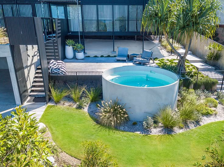 an aerial view of a pool surrounded by greenery and plants in the foreground