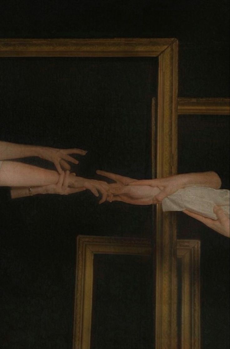 two hands reaching out to touch each other in front of a framed painting on the wall