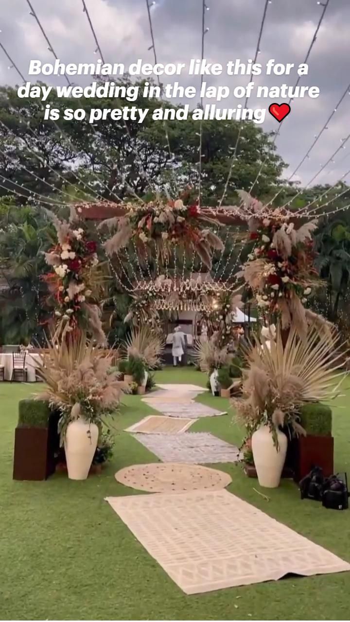 an outdoor ceremony setup with flowers and greenery on the grass, surrounded by string lights