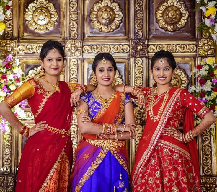 three women standing next to each other in colorful outfits