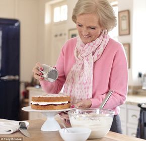 an older woman pouring frosting onto a cake