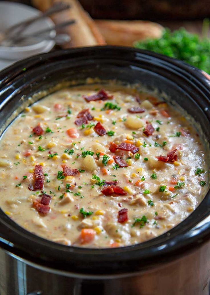 a crock pot filled with soup and garnished with parsley