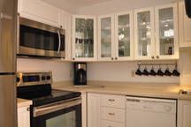 a kitchen with white cabinets and stainless steel appliances