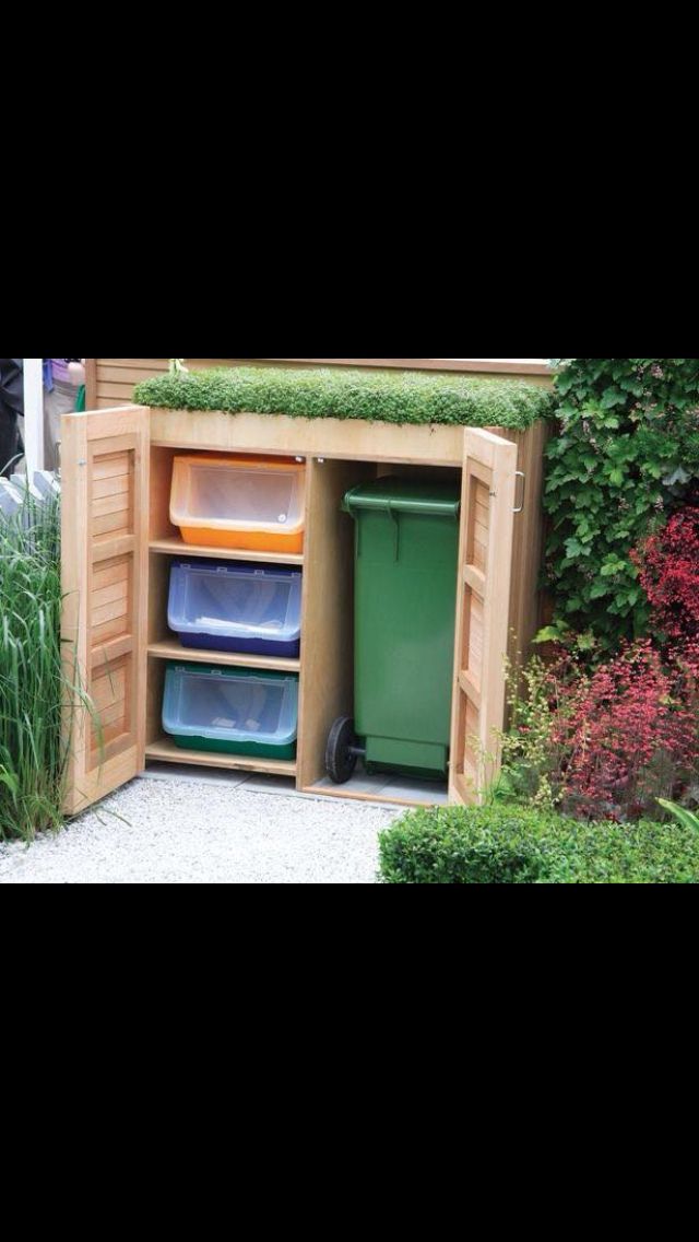 an outdoor storage area with bins and trash cans