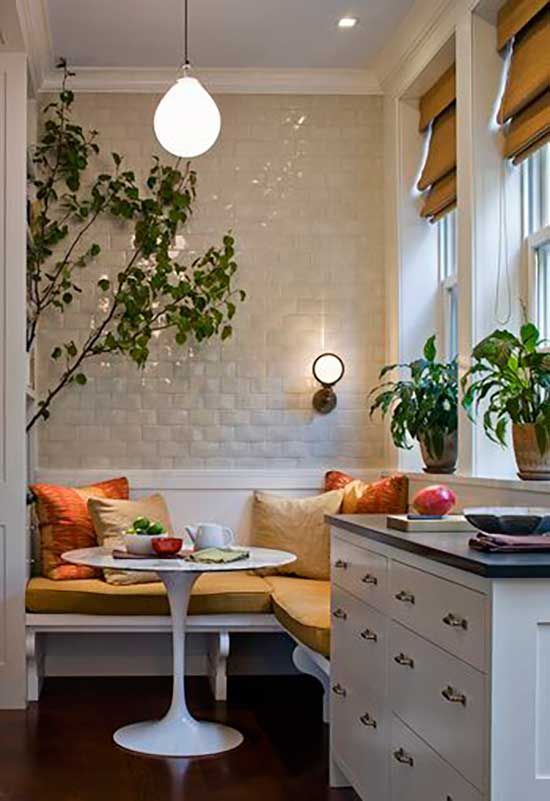 a kitchen with a table and some plants on the counter next to a window sill