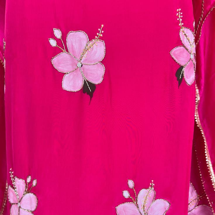 a pink dress with flowers and pearls on it