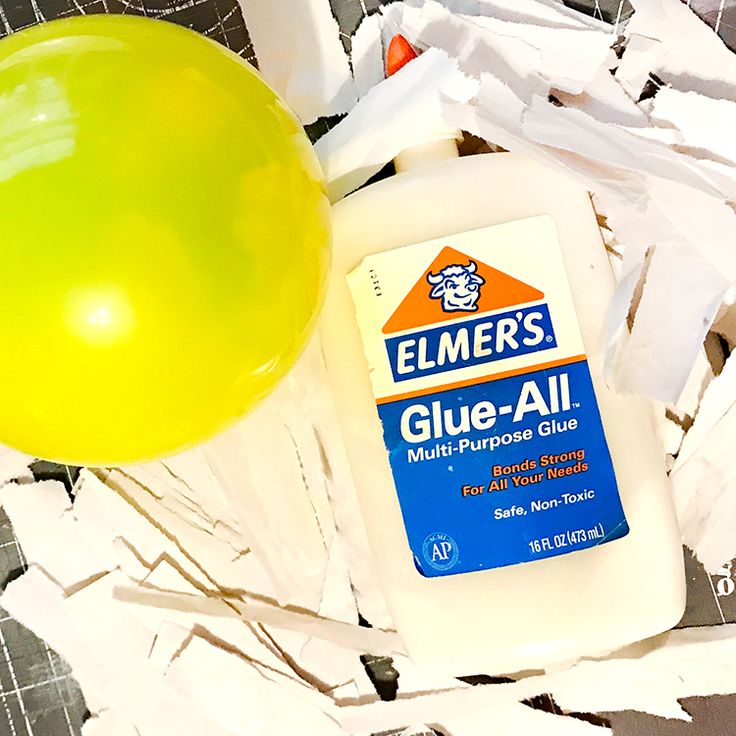 a bottle of glue next to a balloon