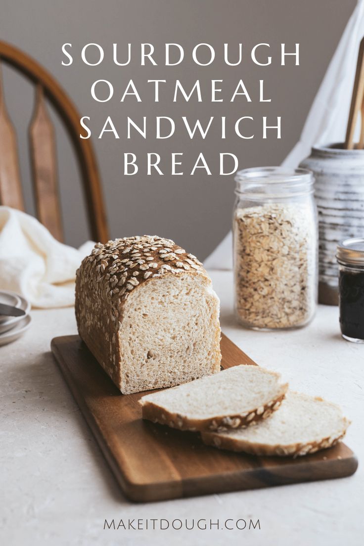 a loaf of bread sitting on top of a wooden cutting board next to a jar of oatmeal