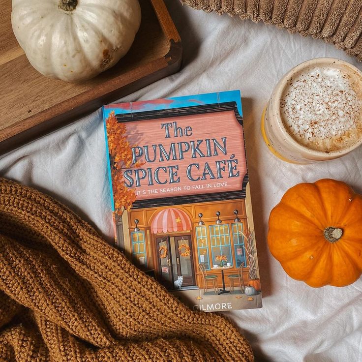 the pumpkin spice cafe book is next to a cup of coffee and an orange pumpkin