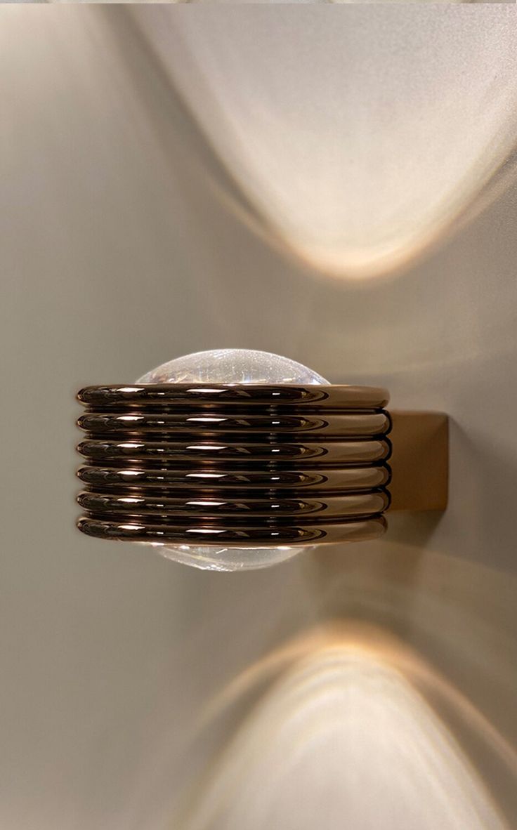 a close up of a wall light with many lights on it's sides and a round object in the middle