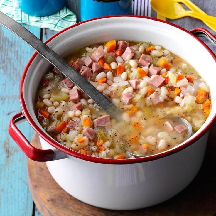 a bowl of ham and bean soup on a wooden table