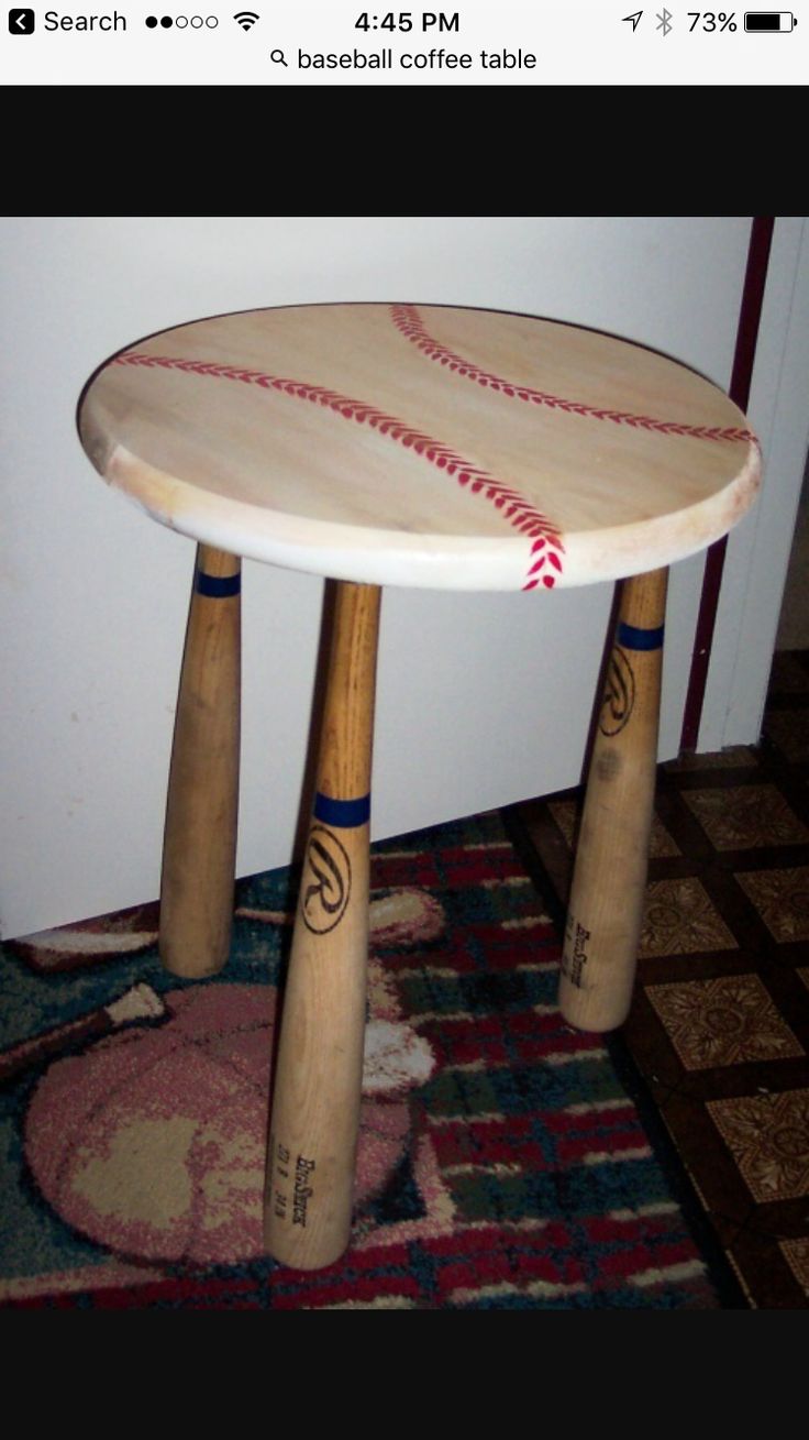 a baseball themed table with two wooden bats on the top and one ball in the middle