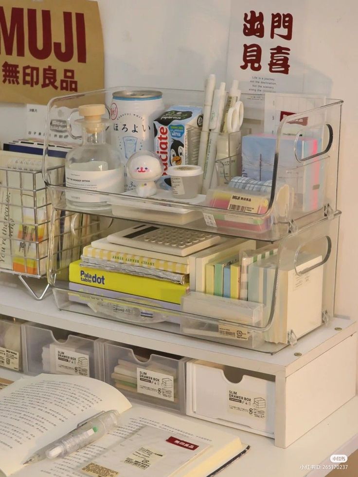 an office desk with several clear bins on top of it and books in front of them