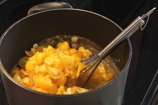 a pan filled with food and a whisk on top of the stove next to an oven