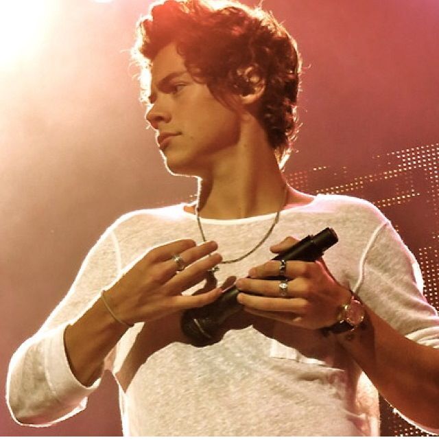 a young man holding a pair of headphones in his hands while standing on stage