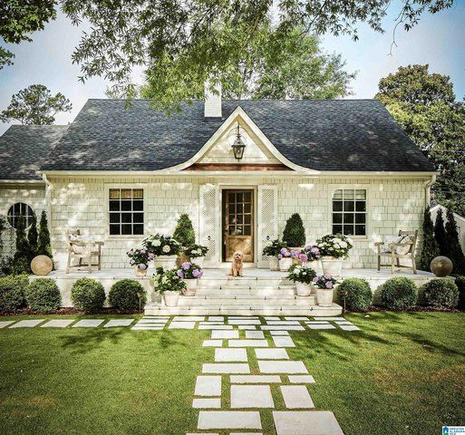 a white house sitting on top of a lush green field